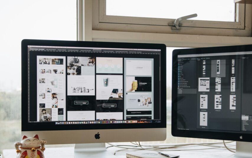 Two monitors setup next to each other on a computer desk.