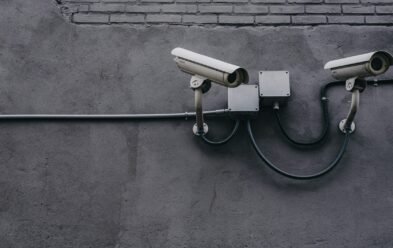 two bullet surveillance cameras attached on wall